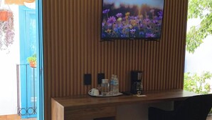 A wooden reception desk with a flat-screen TV mounted above it, displaying a flower scene. - Hotel Casa del Sol (San Cristóbal de las Casas)