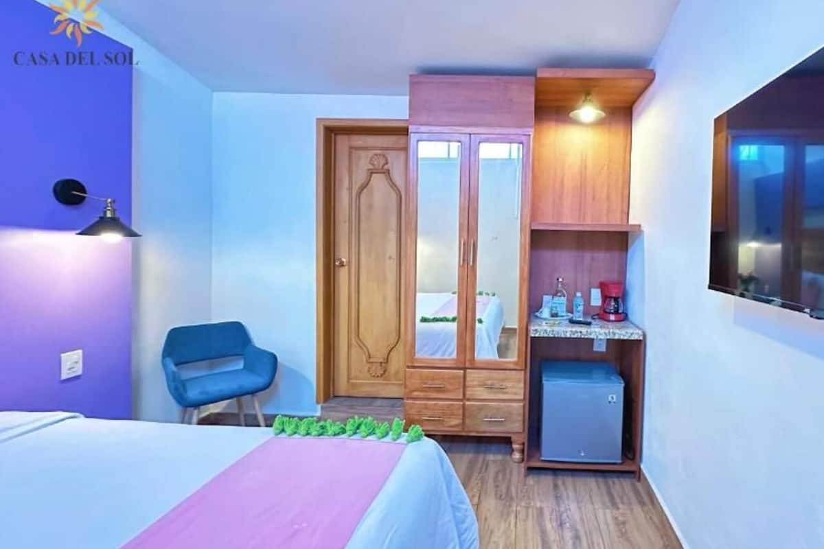 Une chambre à coucher avec un lit, une armoire, un bureau et une chaise.