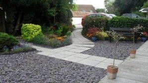 A garden pathway leading to a house with a car parked nearby. - Winchester Arms (Taunton)
