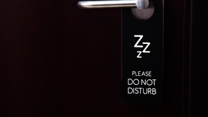 Una puerta con un letrero que dice 'No molestar' y el símbolo de una persona durmiendo.