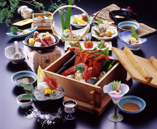 A variety of dishes and drinks arranged on a table, including seafood, vegetables, and a lobster. - Hotel Yunomoto (Komono)