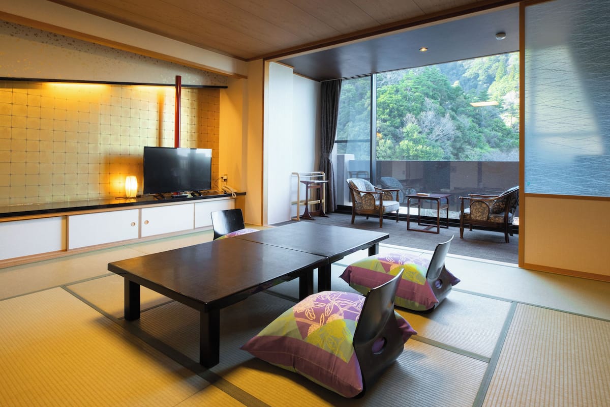Une pièce de style japonais traditionnel, avec un sol recouvert de tatamis, une table basse et des chaises.