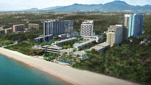 A coastal resort with multiple high-rise buildings, a beach, and lush greenery. - Baan Thew Talay Blue Sapphire (Cha-am)
