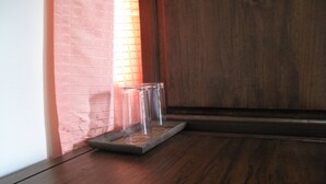 Un plancher en bois, un distributeur d’eau en verre et un mur en briques.