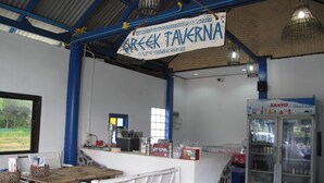 L'intérieur d'un restaurant, avec un comptoir, un espace pour les clients et un réfrigérateur.