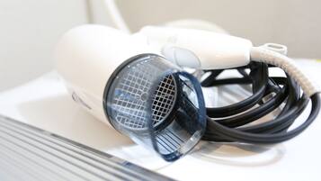 A hairdryer with a cord and a protective cover on a white surface.
