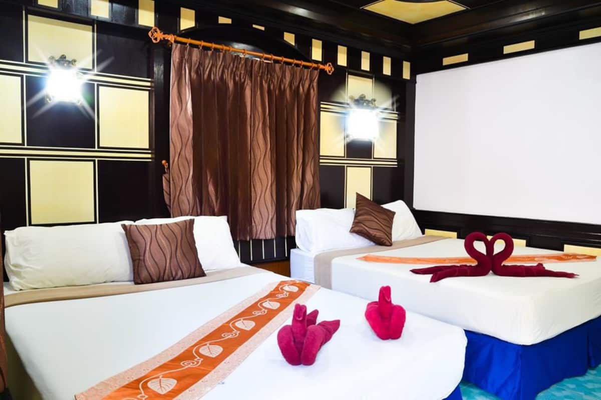 A hotel room with two beds, a large window, and a curtain.