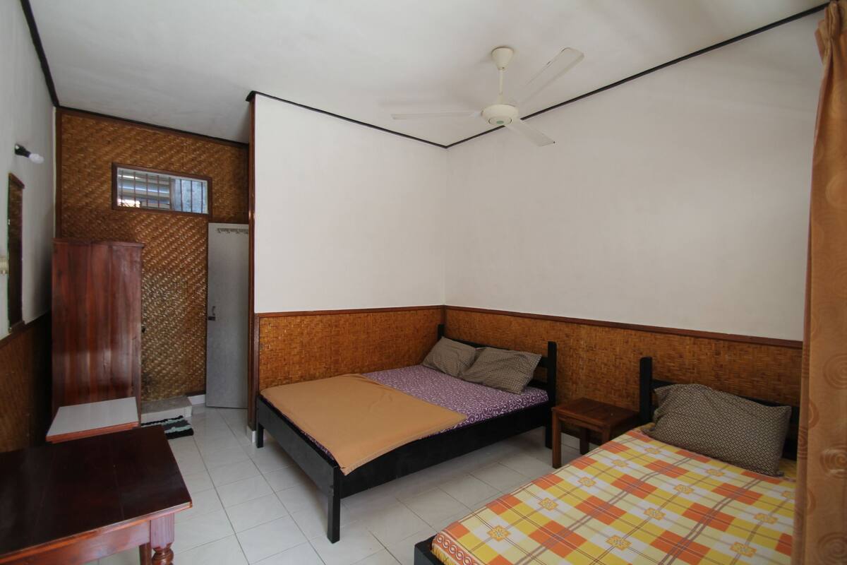 A bedroom with a bed, a desk, and a wardrobe.