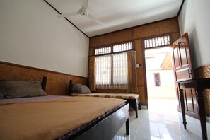 A bedroom with a bed, a desk, and a window with curtains. - Kempu Taman Ayu I (Kuta)