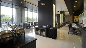Een modern restaurant met een lange toonbank, zwart-wit inrichting en uitzicht op het omliggende landschap.