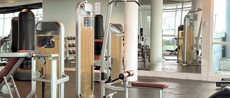 A gym with various exercise machines, including a leg press and a chest press.