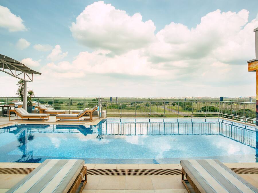 Una piscina al aire libre, sillones reclinables de piscina