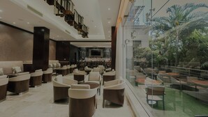 A spacious lobby with a bar area, comfortable seating, and a view of the outdoors. - Crowne Plaza Nairobi Airport by IHG (Nairobi)