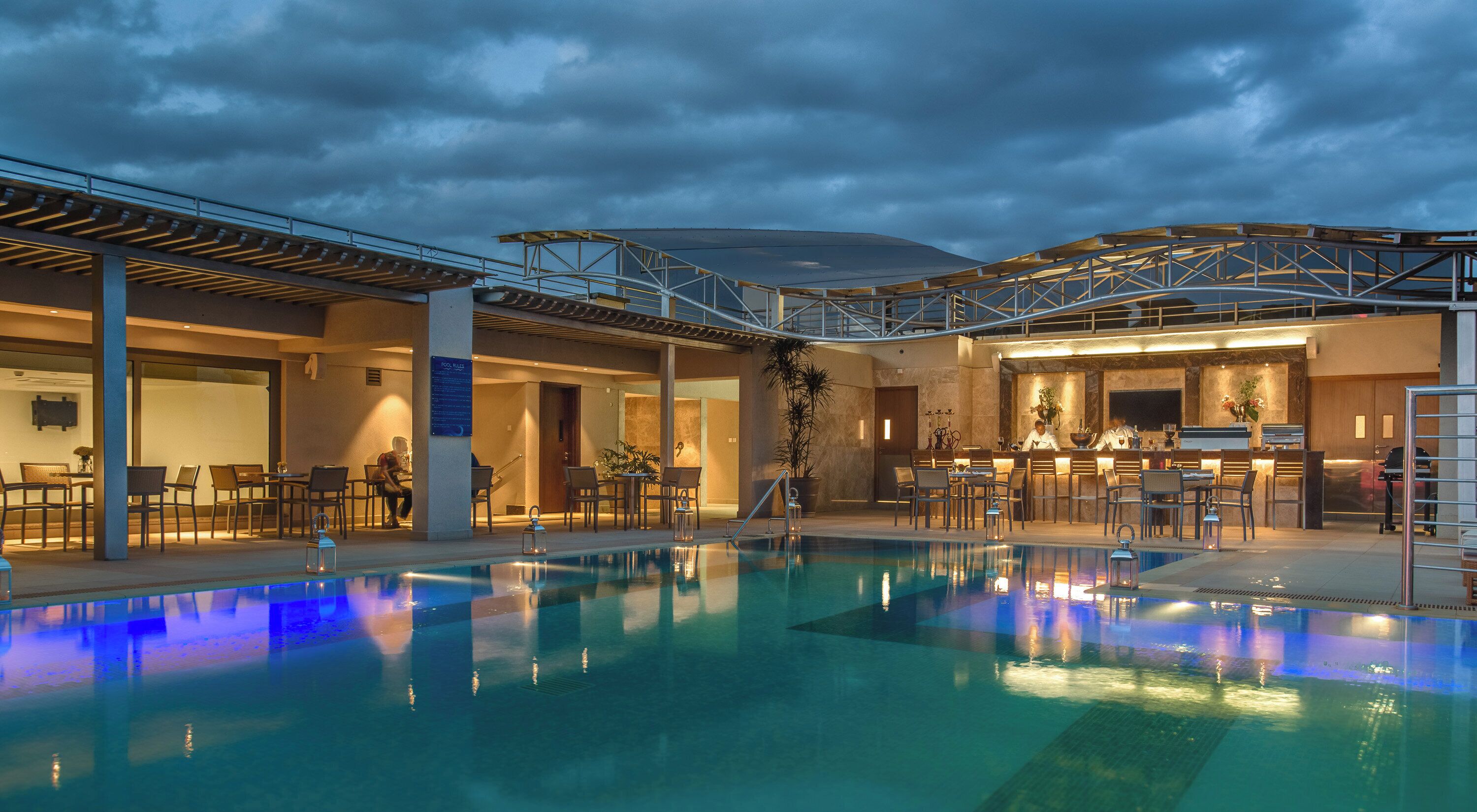 Une piscine intérieure avec un bar et des espaces pour s’asseoir.