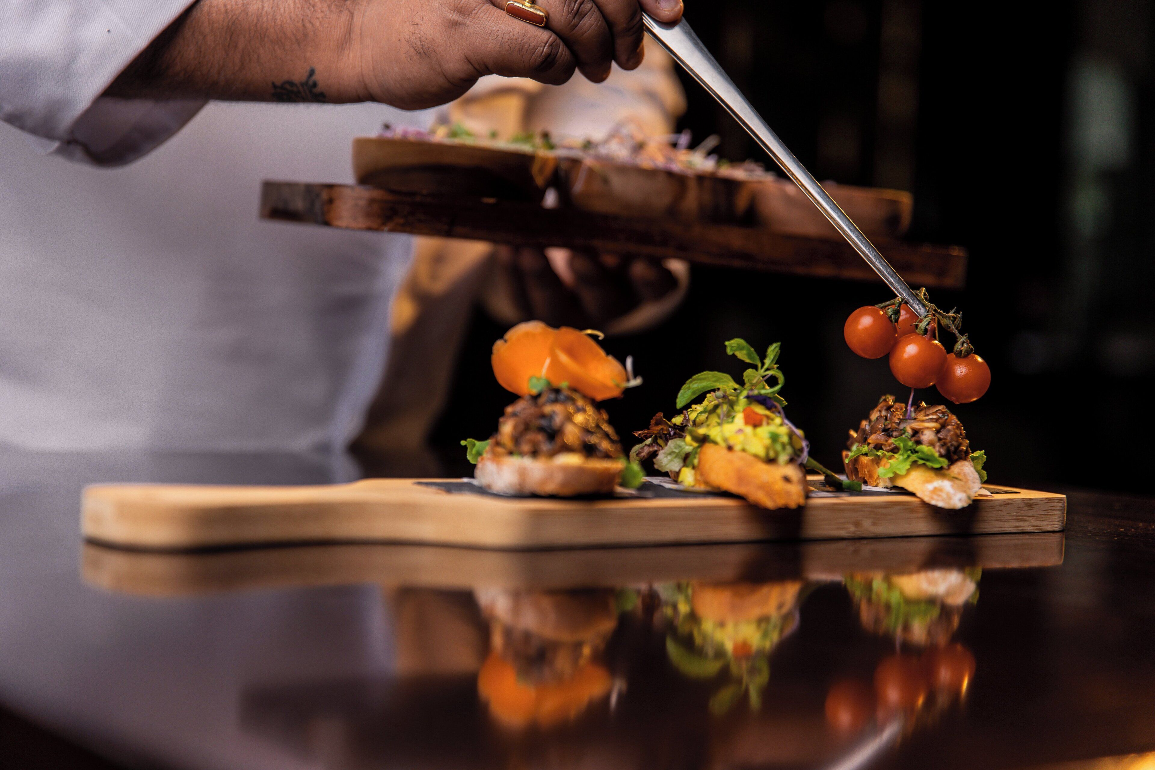 A chef preparing food with a knife and tongs.
