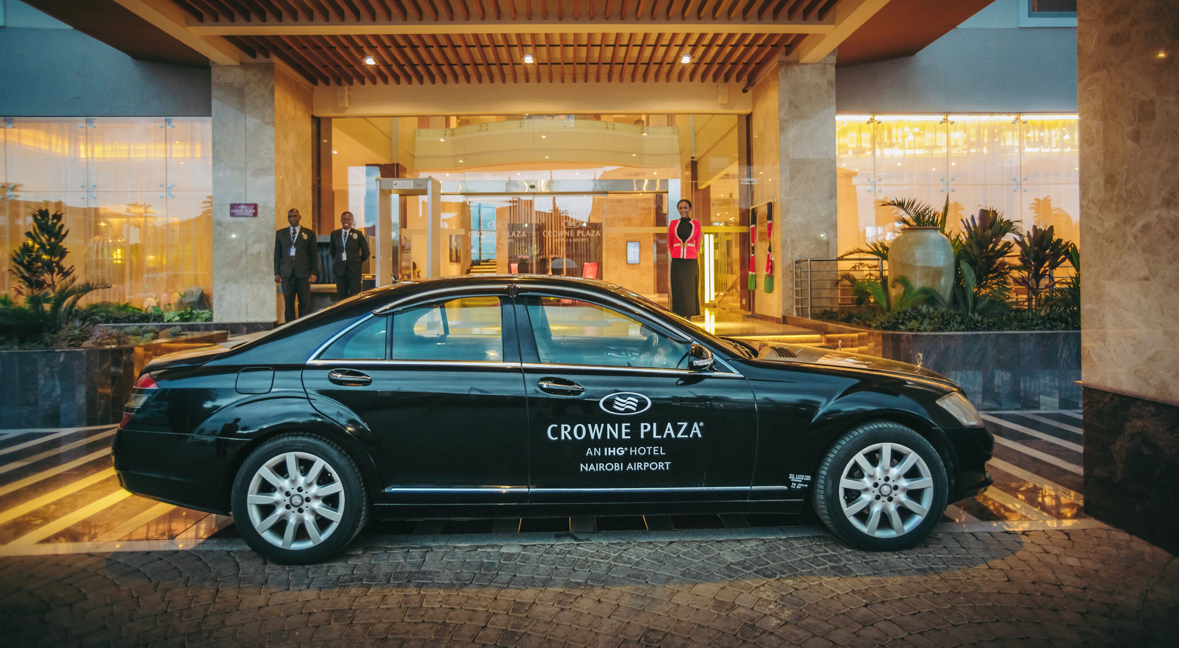 A black car parked in front of Crowne Plaza Nairobi Airport hotel.