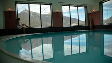 Una piscina techada, sillones reclinables de piscina