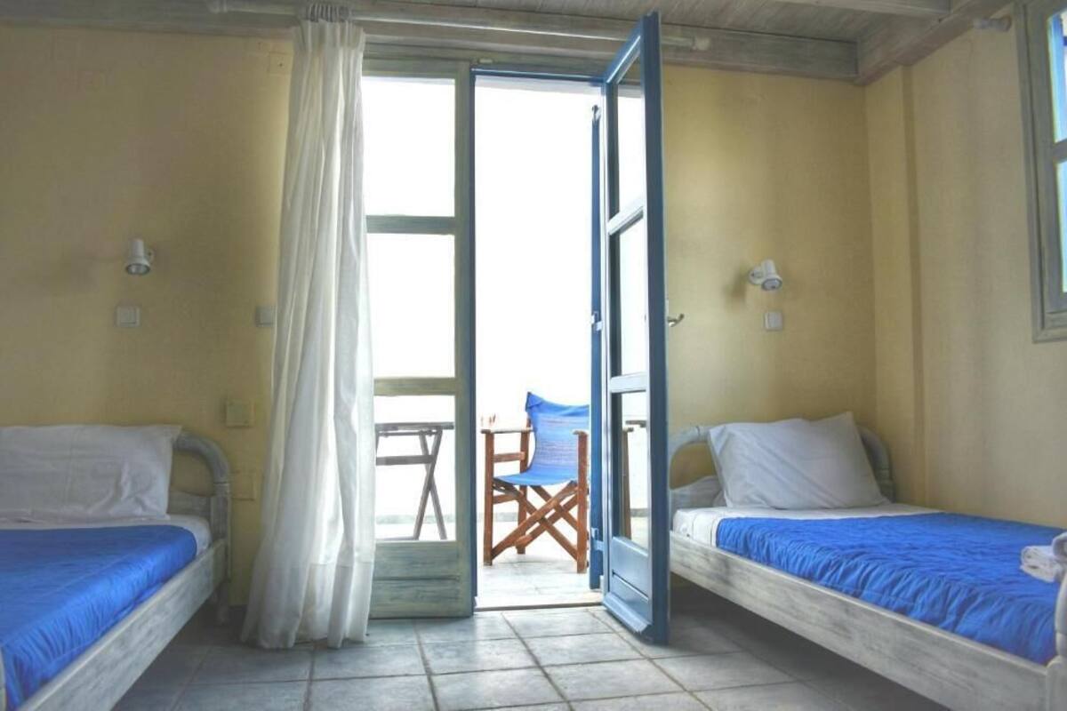 A room with two beds, a table, and a chair.