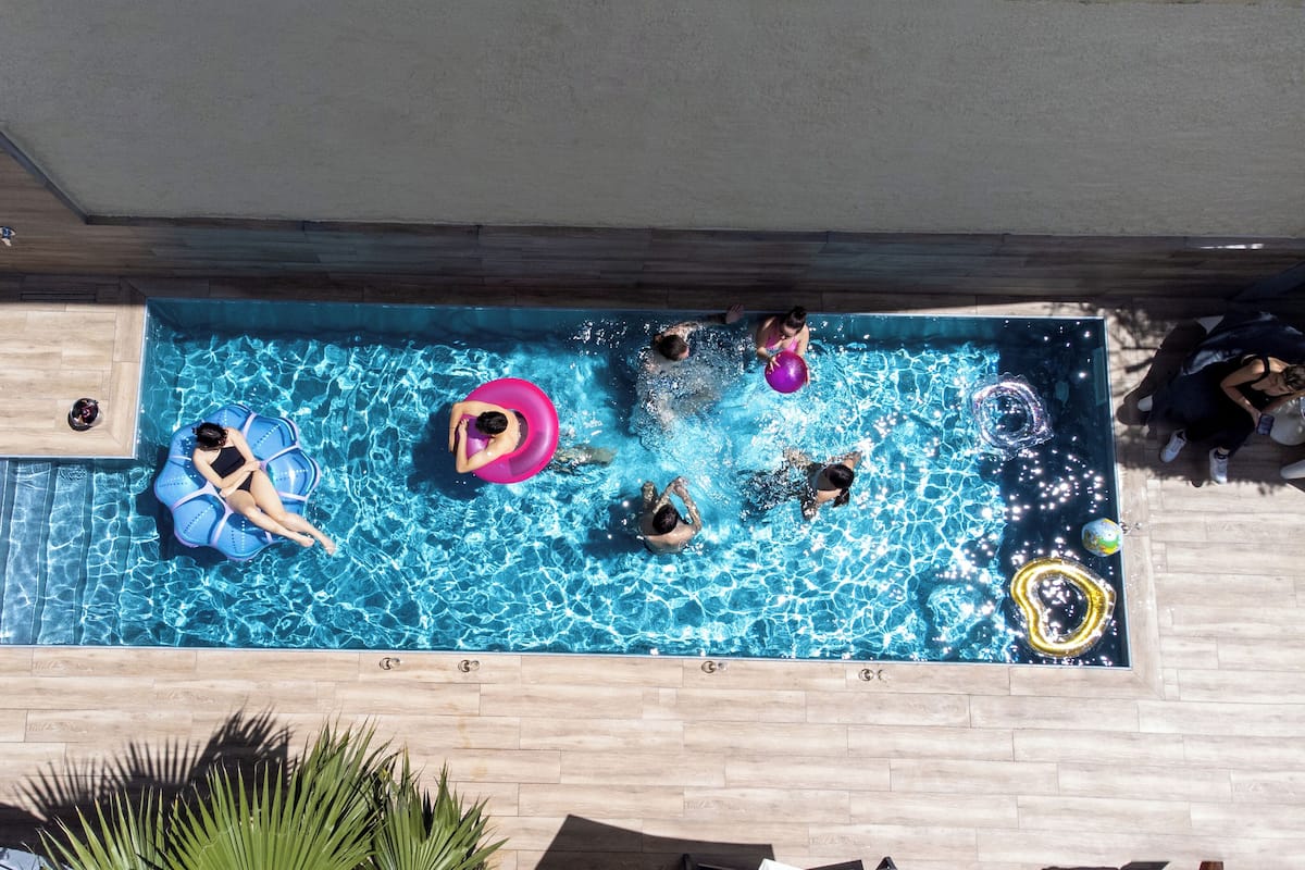 A rectangular swimming pool with a wooden deck surrounding it.