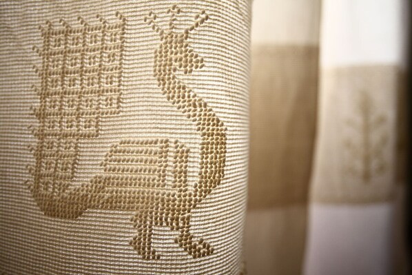A close-up of a textured fabric with a detailed embroidered design.