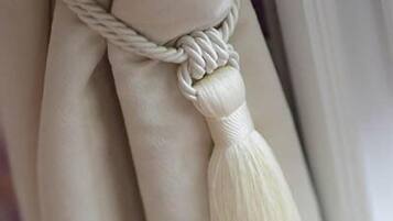 A close-up of a white rope with a tassel tied to a white object.