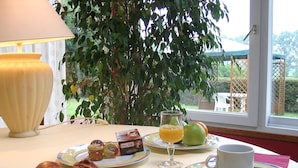 Una mesa de desayuno con croissants, jugo y una taza de café.