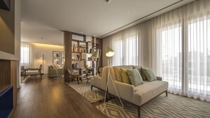 Una sala moderna con un sofá, una lámpara de pie y una estantería.