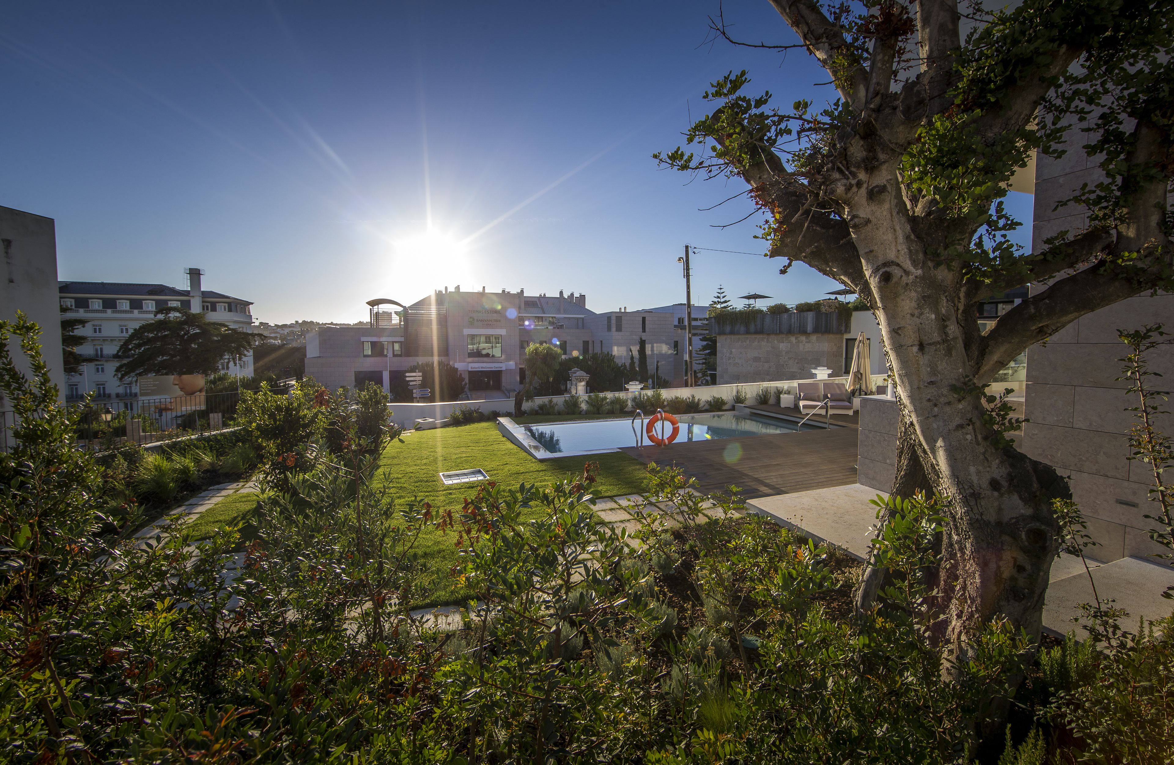 Un patio con piscina, rodeado de edificios y vegetación.
