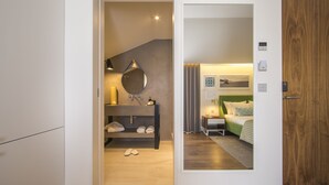 Un dormitorio moderno con armario empotrado, una mesita de noche con lámpara y un espejo grande en la pared.