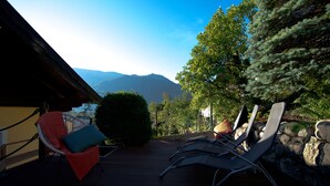 Una terraza con sillones de descanso y vistas a las montañas.