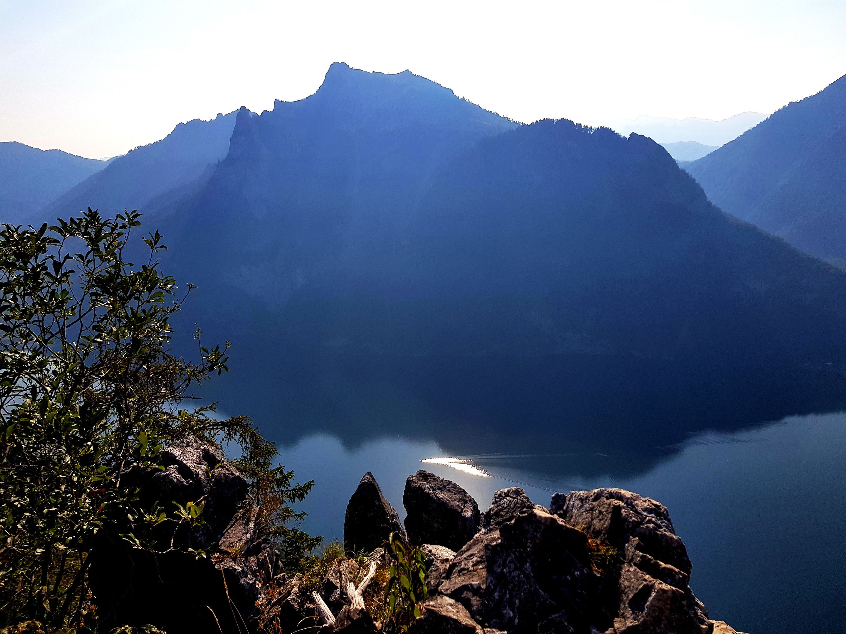 Un paisaje montañoso con un lago y terreno rocoso en primer plano.