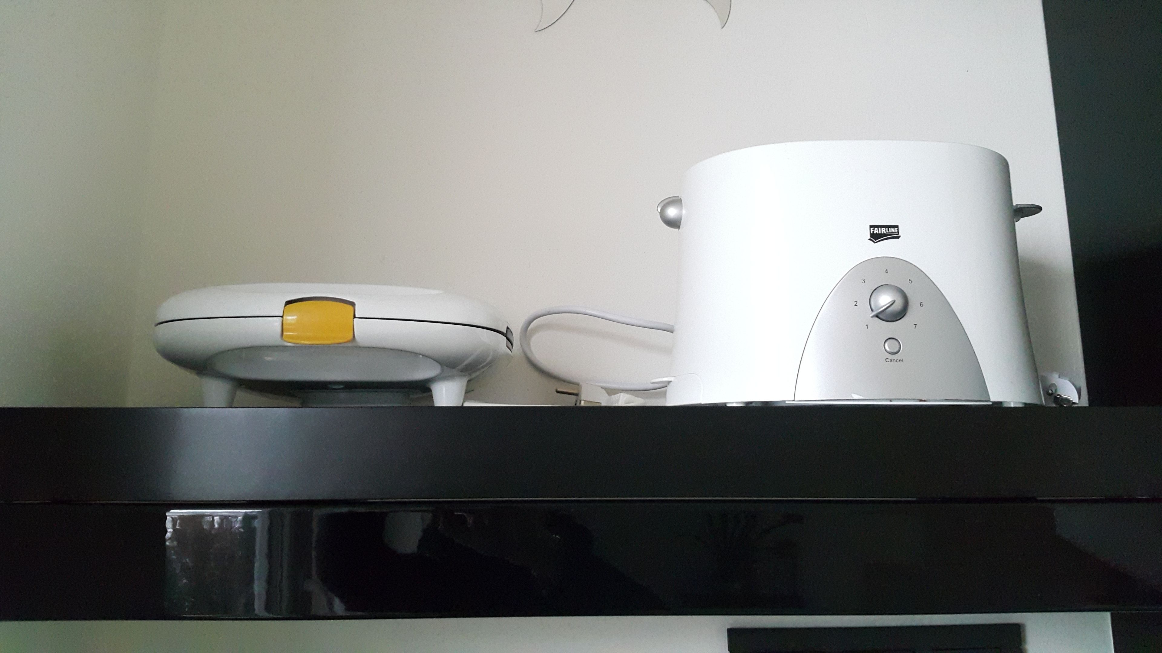 A kitchen with a coffee maker, a kettle, and a toaster on the counter.