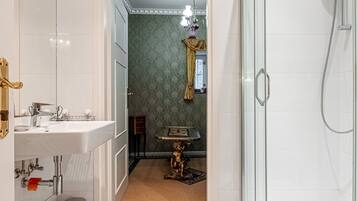 A modern bathroom with a glass-enclosed shower, a white sink, and a vanity.