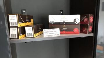 Een plank met diverse koffieproducten, waaronder dozen met de aanduiding 'Caffissimo Black White' en 'Espresso'.