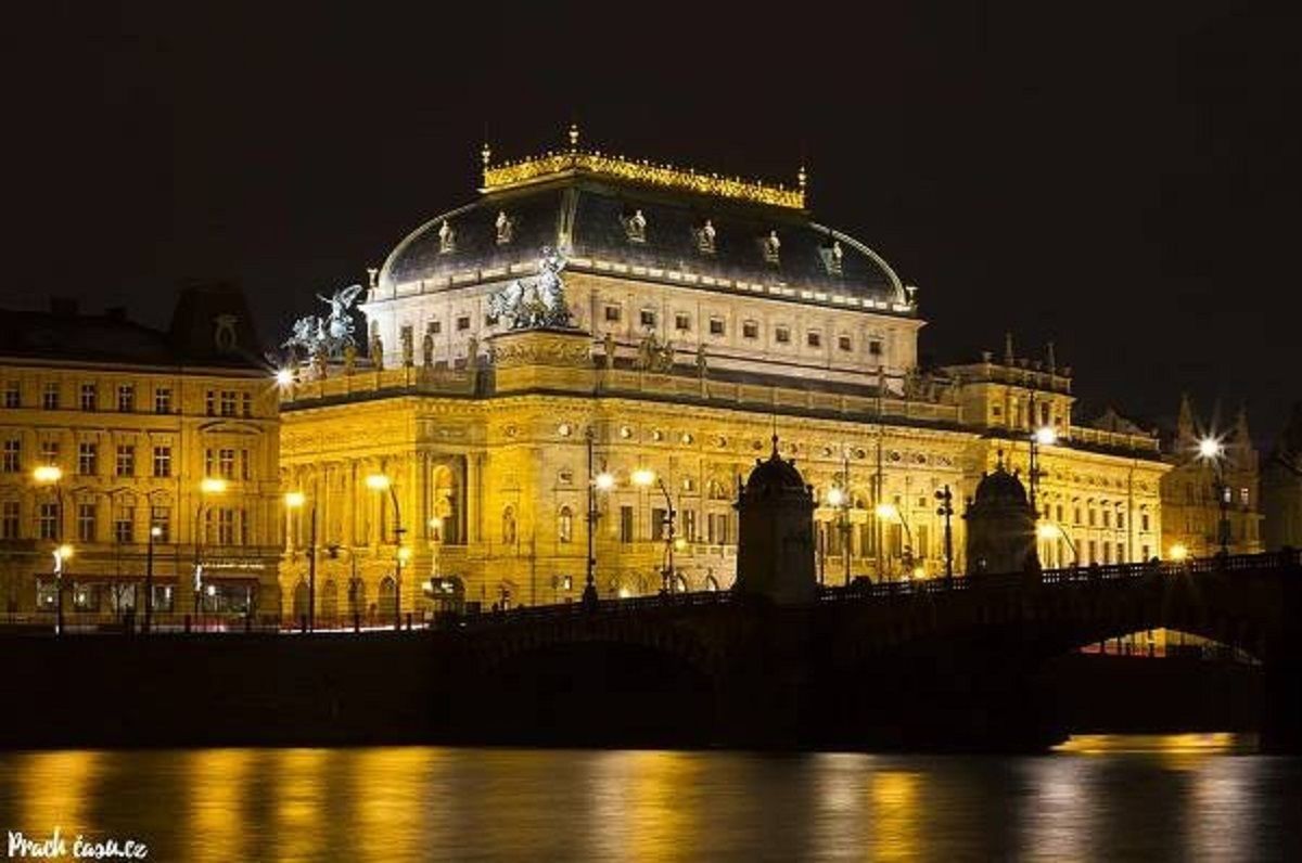 A historic building with a prominent dome and classical architecture, located by a river.