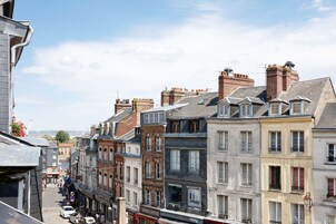 Una hilera de edificios históricos con diversos estilos arquitectónicos, incluyendo fachadas de ladrillo y múltiples pisos.