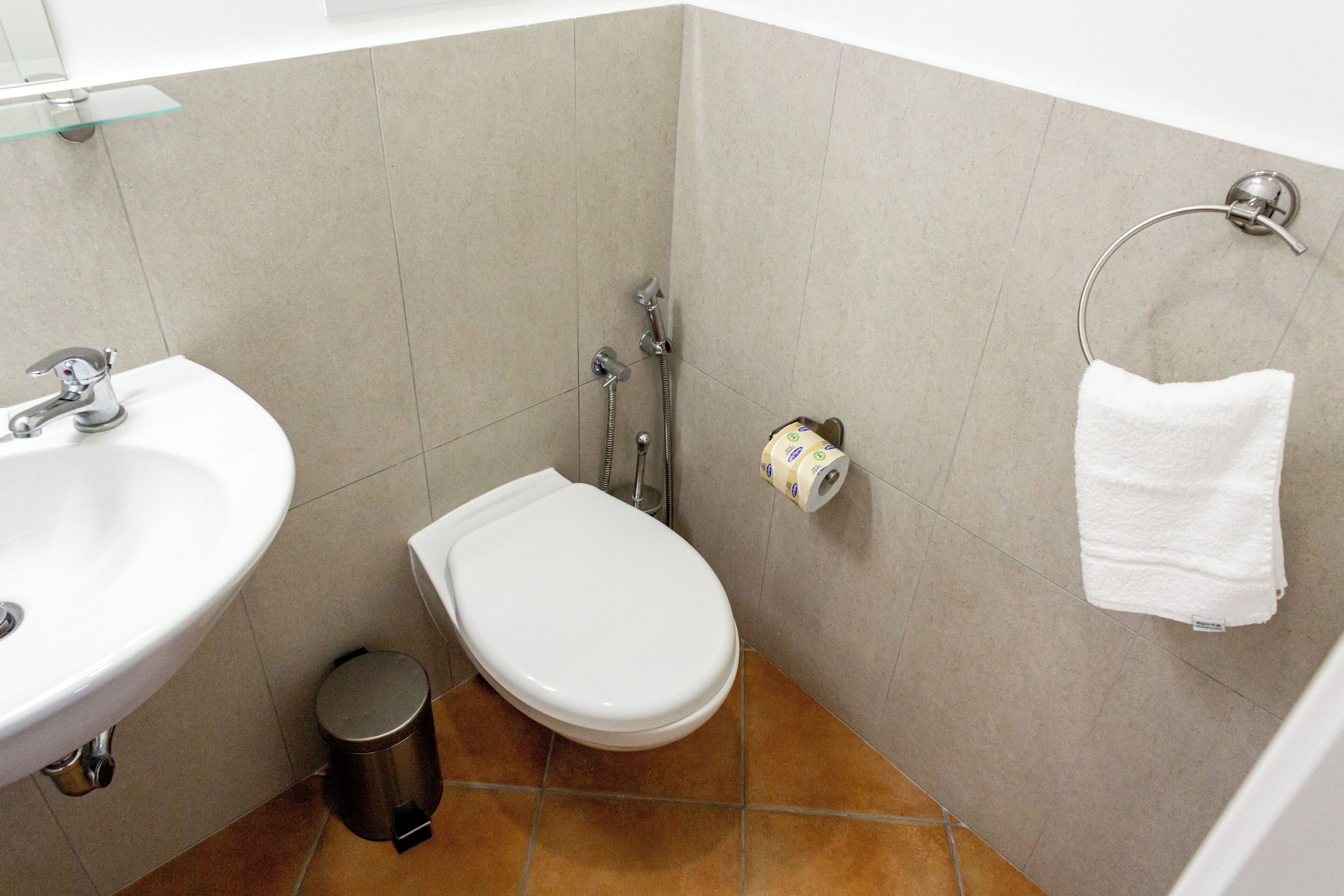 Une salle de bain équipée d’un lavabo, de toilettes et d’un porte-serviettes.