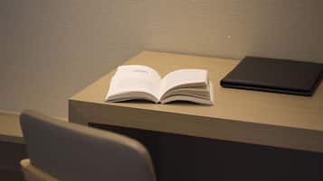 Un libro abierto sobre una mesa de madera, con otro libro cerrado a su lado.