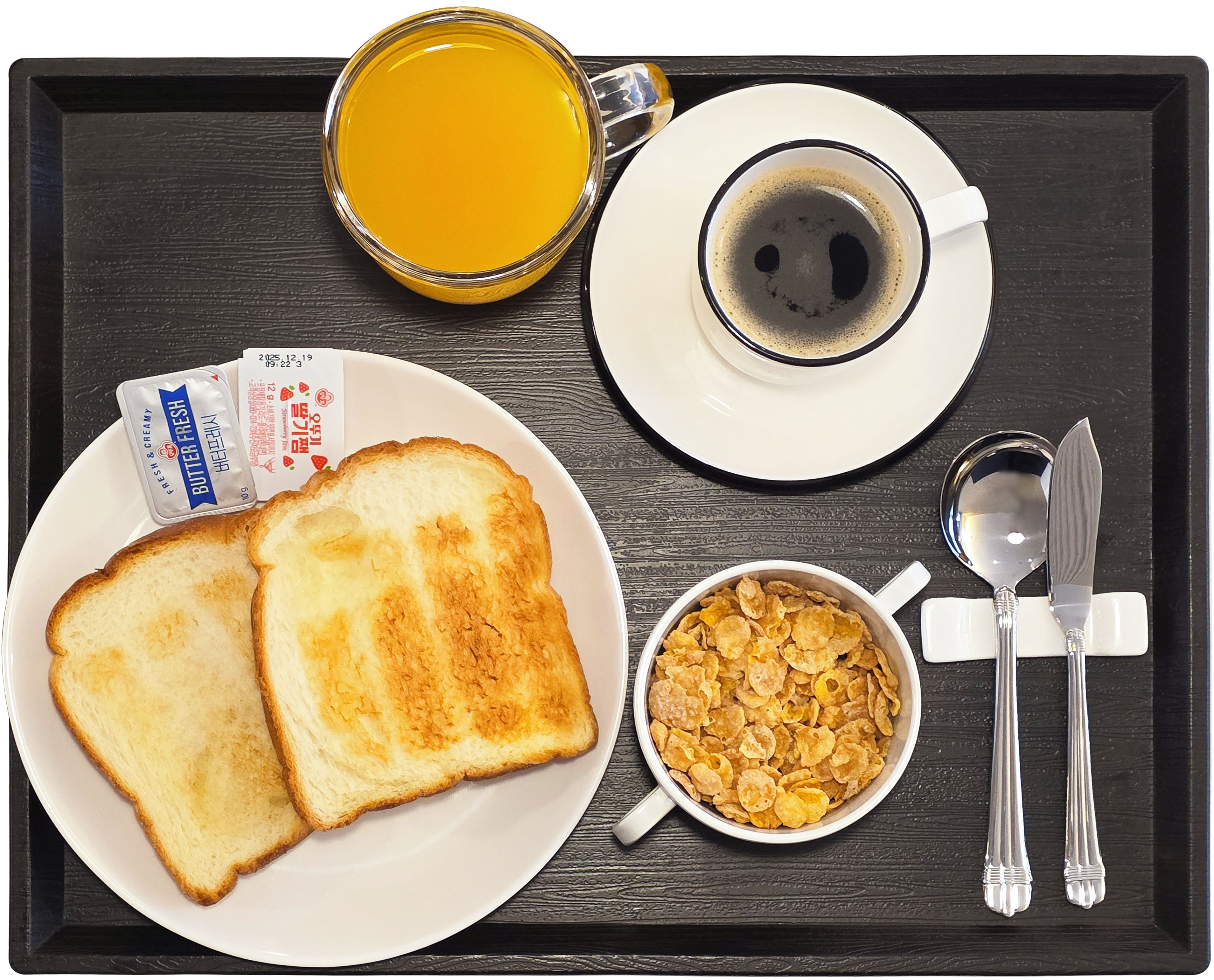 Een dienblad met toast, een kom ontbijtgranen, een kop koffie en een glas sinaasappelsap.