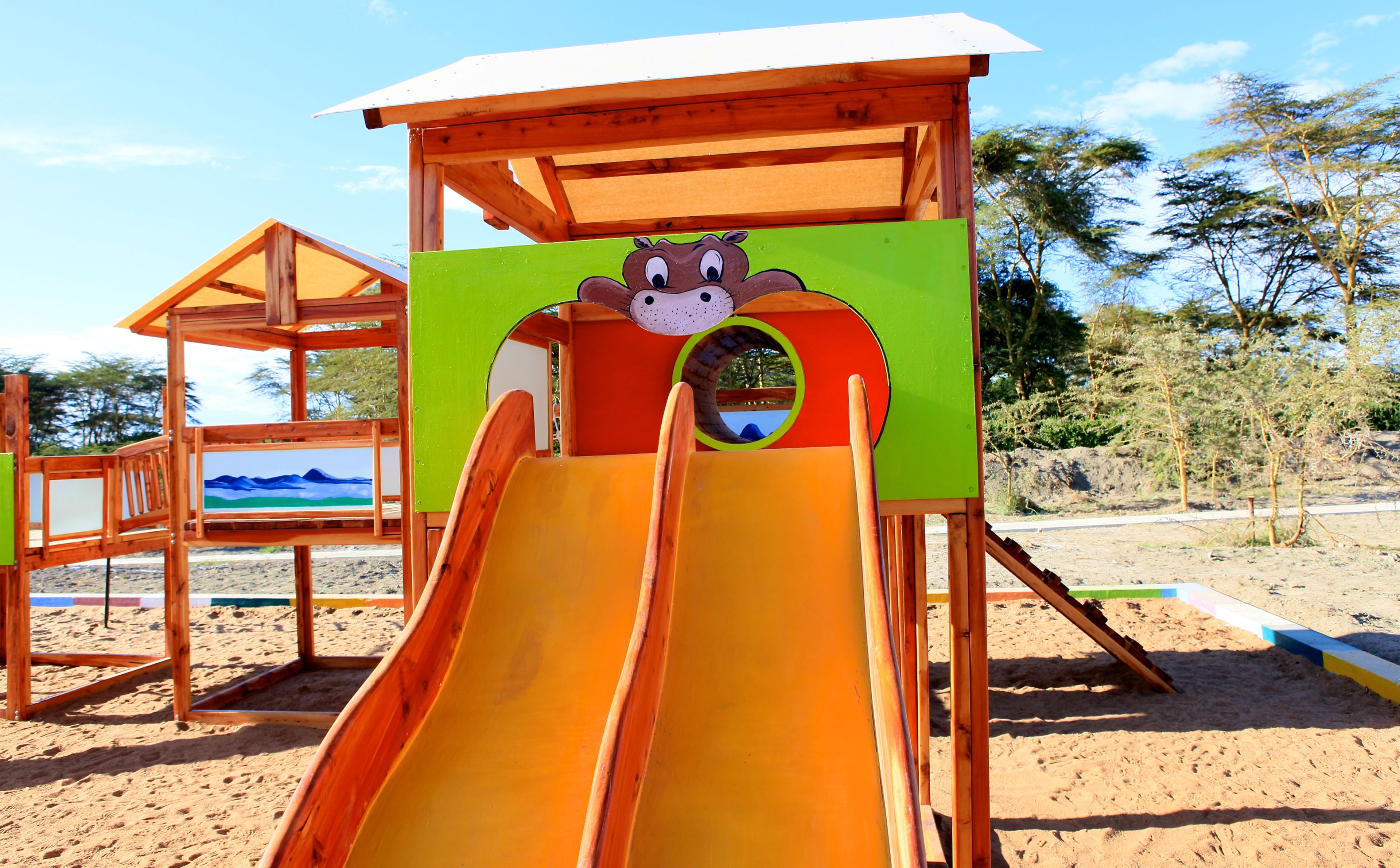 Une structure de jeu en bois, dotée d’un toboggan et d’une plateforme d’observation.