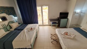 Habitación de hotel con dos camas, un escritorio, un televisor y un balcón.