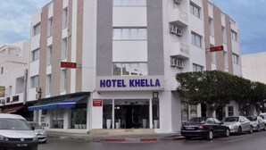 Un hotel de varios pisos con un letrero llamativo que dice "HOTEL KHELLA".
