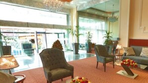 A spacious lobby with a modern chandelier, comfortable seating, and large windows offering a view of the outside. - Abyssinia Renaissance Hotel (Addis Ababa)