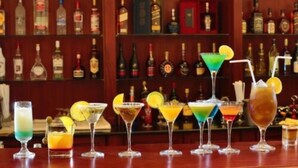 A bar with various colorful cocktails and a selection of liquor bottles in the background. - Abyssinia Renaissance Hotel (Addis Ababa)