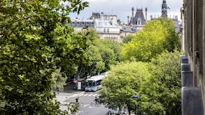 Vista de una calle con edificios, árboles y un autobús.