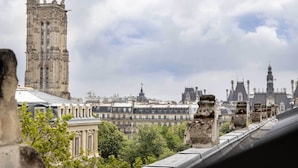Un edificio histórico con arquitectura intrincada, una torre destacada y vistas de la ciudad circundante.