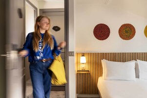 A hotel room with a bed, a nightstand, and a wall with three circular wall art pieces.