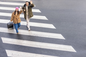 A pedestrian crossing with two individuals walking across.
