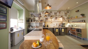 A modern kitchen with a central island, stainless steel appliances, and a variety of kitchenware.