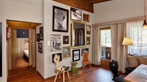 A room with wooden flooring, a dining table, chairs, a mirror, and various framed pictures on the walls. - A CASA Juwel - Ski in & Out Appartements (Soelden)